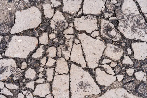 Yolda çukurlar var ve asfalt parçalanmış. Metin için kopyalama alanı olan arkaplan