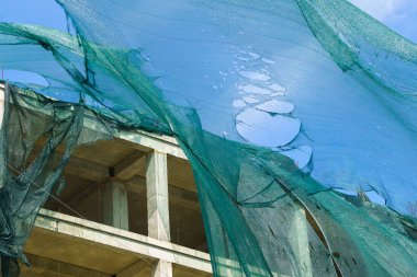 Kasırga rüzgarı tarafından yırtılan iskelelerde koruyucu ağ. Seçici odaklı arkaplan ve metin için alanı kopyala.