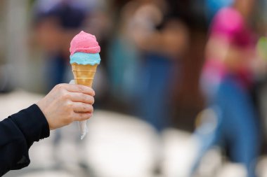 Bir kadının eli dondurmayı tutuyor. Bulanık arkaplan ve metin için kopyalama alanı olan ellere seçici odak.