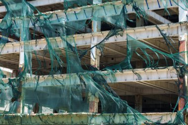 Kasırga rüzgarı tarafından yırtılan iskelelerde koruyucu ağ. Seçici odaklı arkaplan ve metin için alanı kopyala.