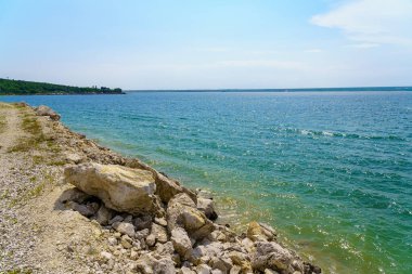 Taze bir rezervuarın kayalık kıyısı. Seçici odaklı arkaplan ve metin için alanı kopyala.