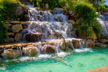 Yapay şelale. Sıcak havalarda popüler bir yer. Seçici odaklı arkaplan ve metin için alanı kopyala