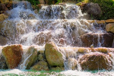 Yapay şelale. Sıcak havalarda popüler bir yer. Seçici odaklı arkaplan ve metin için alanı kopyala
