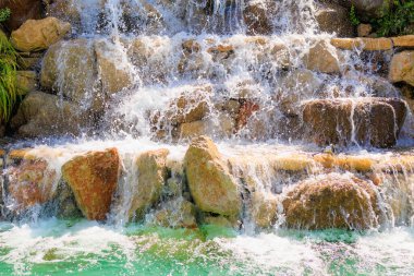 Yapay şelale. Sıcak havalarda popüler bir yer. Seçici odaklı arkaplan ve metin için alanı kopyala