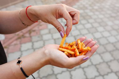 Kadın eli kraker, atıştırmalık ve fast food konsepti tutuyor. Bulanık arkaplan ve metin için kopyalama alanı olan ellere seçici odak.