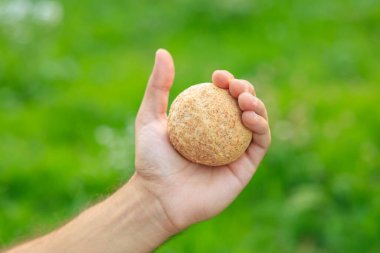 Adamın elinde mini ekmek, atıştırmalık ve fast food konsepti var. Bulanık arkaplan ve metin için kopyalama alanı olan ellere seçici odak.