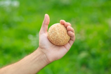 Adamın elinde mini ekmek, atıştırmalık ve fast food konsepti var. Bulanık arkaplan ve metin için kopyalama alanı olan ellere seçici odak.