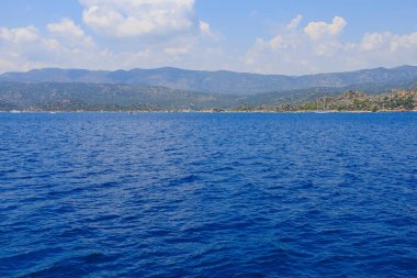 View of the rocky shore from the sea. Background with selective focus and copy space for text. Mediterranean Sea in Turkey. Popular tourist places clipart