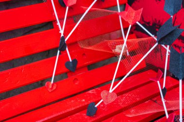 Aşk tanrısının okları kırmızı tahta bir bankta. Seçici odaklı arkaplan ve metin için alanı kopyala