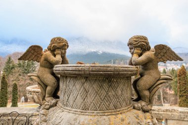 Dağlık arazinin ortasındaki çeşmede dinlenen antik taş melekçikler..