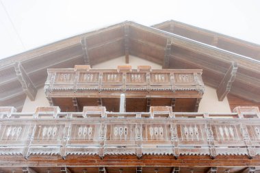 Kış harikalar diyarında karla kaplı ahşap bir dağ evi cephesi.