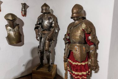 Medieval suit of armor display in historical museum interior. clipart