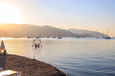 Bir tatil köyünde denizde güzel bir gün doğumu. Seçici odaklı arkaplan ve metin için alanı kopyala.