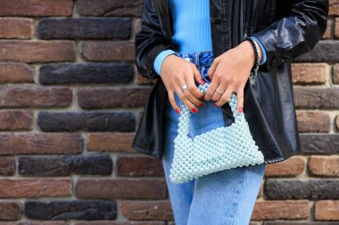 Genç bir bayanın elinde şık bir çanta. Seçici odaklı arkaplan ve metin için alanı kopyala