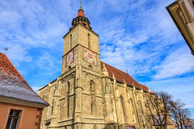 Saat kulesi ve çan kulesi olan büyük bir kilise. Saat kulesi kilisenin sol tarafında. 14 Aralık 2024 Brasov Romanya