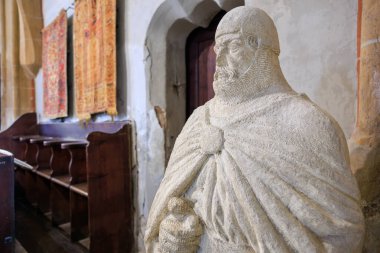 Bornoz giymiş ve asa tutan bir adamın heykeli. Heykel, ahşap bankları ve eski bir kilisesi olan bir odaya yerleştiriliyor. 14 Aralık 2024 Brasov Romanya