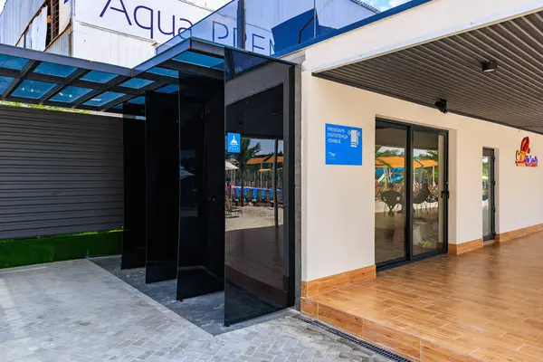 Mavi işaretli bir bina. Su parkında duş. Binanın siyah bir tentesi ve cam bir kapısı var. 8 Haziran 2024 Balti Moldova