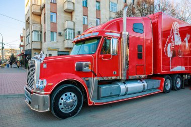 Yanında Coca Cola reklamı olan kırmızı bir kamyonet. Kamyon tuğla bir yolda park halinde. 27 Aralık 2023 Balti Moldova