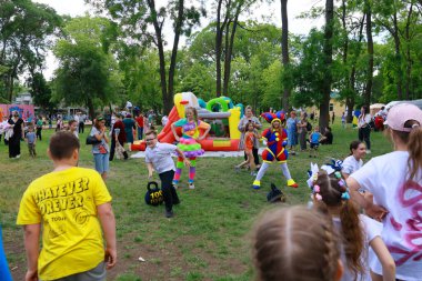 Çocuklar güneşli bir günde eğlendiricilerle ve şişiricilerle açık hava park aktivitelerini severler. 31 Mayıs 2024 Balti Moldova.