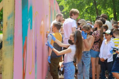 Çocuklar açık hava tuvalinde grafiti sanatı yaratıyorlar. 31 Mayıs 2024 Balti Moldova.