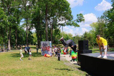 Güneşli bir günde genç erkek dansçı ve izleyicilerle açık hava parkı gösterisi. 31 Mayıs 2024 Balti Moldova.