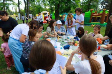 Yaratıcı faaliyetlerde bulunan çeşitli insanlarla birlikte açık hava el sanatları atölyesi. 31 Mayıs 2024 Balti Moldova.