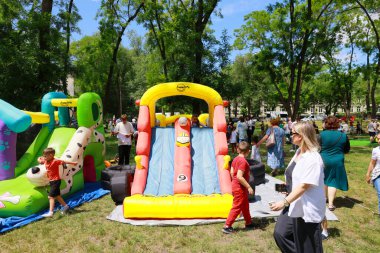 Açık hava çocuk etkinliğinde parktaki ailelerle birlikte renkli şişme kaydırak. 31 Mayıs 2024 Balti Moldova.