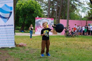 Beyaz çocuk, balonla parkta açık hava festivalinde oynuyor. 31 Mayıs 2024 Balti Moldova.