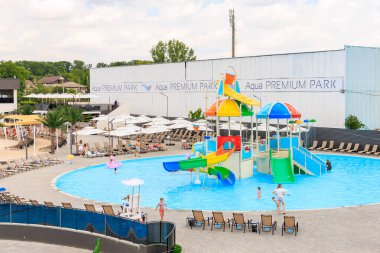 Büyük bir havuz, kaydırak ve su sıçratma yastığı. Havuz sandalyeler ve şemsiyelerle çevrilidir. 8 Haziran 2024 Balti Moldova