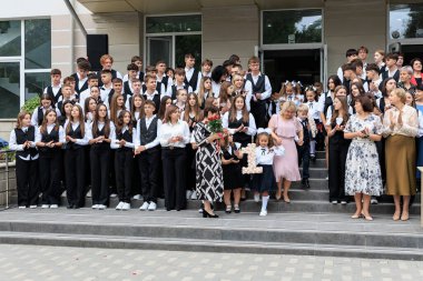 Genç öğrenciler ve öğretmenlerle merdivenlerde mezuniyet töreni. 2 Eylül 2024 Balti Moldova.