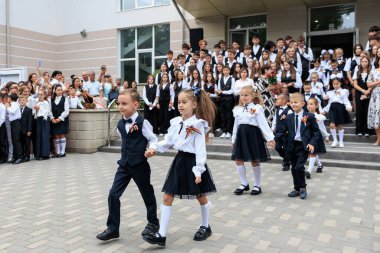 Okul seremonisini yöneten üniformalı beyaz çocuklar. 2 Eylül 2024 Balti Moldova.