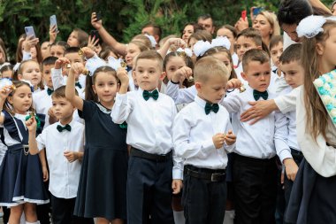 Okul üniformalı bir grup beyaz çocuk açık hava törenine katılıyor. 2 Eylül 2024 Balti Moldova.