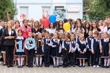 Okul etkinliklerinde balonları ve öğretmenleri olan bir grup beyaz çocuk. 2 Eylül 2024 Balti Moldova.