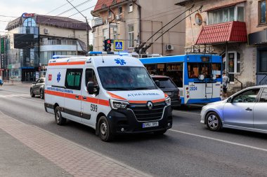 Kalabalık şehir caddesinde trafik ve binalarla dolu acil ambulans. 11 Eylül 2024 Balti Moldova.