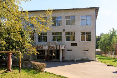 Önünde bir tabela ve bir sürü penceresi olan büyük bir bina. Bina eski ve çok karakterli. Şehir Boks Okulu adını Petuhov 'dan almıştır. 23 Eylül 2024 Balti Moldova