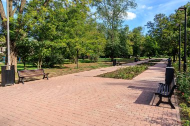 Tuğla yolu ve bankları olan bir park. Banklar boş. Park sessiz ve huzurlu. 25 Eylül 2024 Balti Moldova