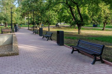 Tuğladan geçitli ve birkaç banklı bir park. Banklar boş. Park sessiz ve huzurlu. 25 Eylül 2024 Balti Moldova