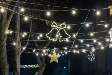 Geceleri çanları, yıldızları ve kar taneleri süslemeleri olan bayram ışıkları..