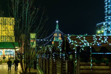 Geceleyin süslenmiş ağaçlar ve parlak ışıklarla Noel pazarını karıştırmak. 27 Aralık 2024 Balti Moldova.