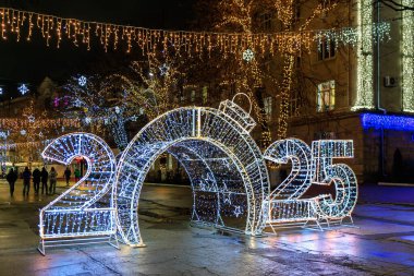 Şehir meydanında 2025 aydınlatılmış şenlikli gece gösterisi. 27 Aralık 2024 Balti Moldova.