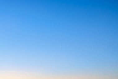 Açık mavi gökyüzü ve uzakta küçük bir uçak..