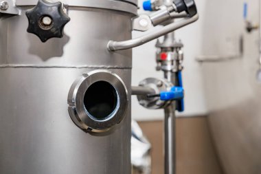 Fabrikada vanaları ve boruları olan paslanmaz çelik endüstriyel ekipmanlar..