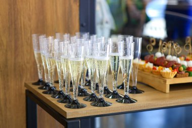 Şampanya kadehi, şampanya ve ahşap bir masada aperatifler. 18 Eylül 2024 Balti Moldova.