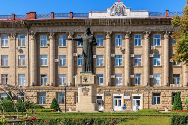 Anıtı ve güneşli bahçeleri olan tarihi bir bina. 8 Temmuz 2024 Balti Moldova.