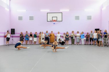 Bir grup kadın jimnastikçi jimnastik salonunda seyirciler izlerken gösteri yapıyor. 17 Temmuz 2024 Balti Moldova.