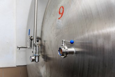 Paslanmaz çelik bira deposu, kapakçık ve duvarda dokuz numara işareti var..