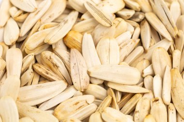 Bir yığın beyaz ayçiçeği çekirdeği. Bazıları çatlamış, bazıları bir bütün. Tohumlar yığının her tarafına saçılmış.