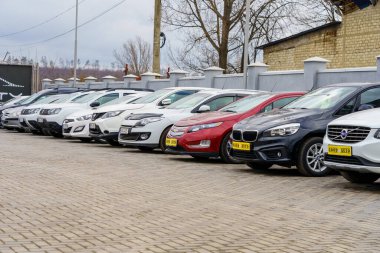Bulutlu bir günde açık hava parkında sıra sıra park edilmiş arabalar. 14 Şubat 2023 Balti Moldova.