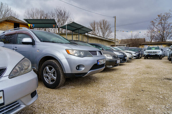 Используется автостоянка с различными моделями на открытой парковке под облачным небом. 14 февраля 2023 года Бельцы Молдова.