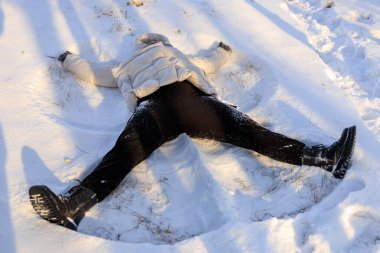 Kar meleği yapan genç bir kadın. Seçici odaklı arkaplan ve metin için alanı kopyala